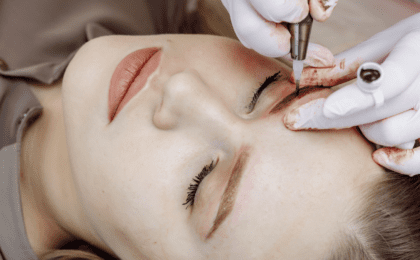 woman doing permanent makeup on her brows