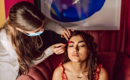 woman getting makeup from expert artist