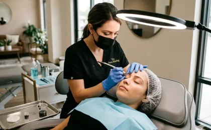 expert from the nano blading giving touch ups to a woman